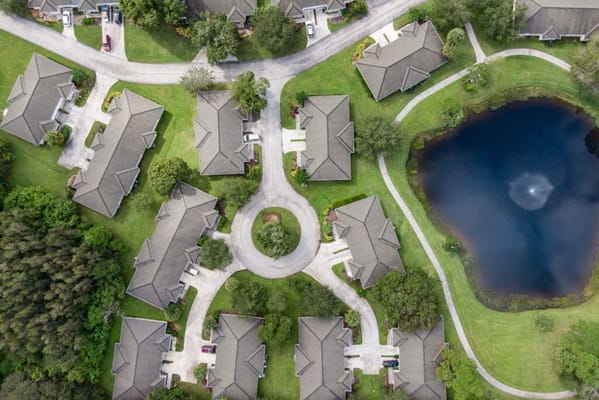 Aerial view of a senior living campus with homes and a pond