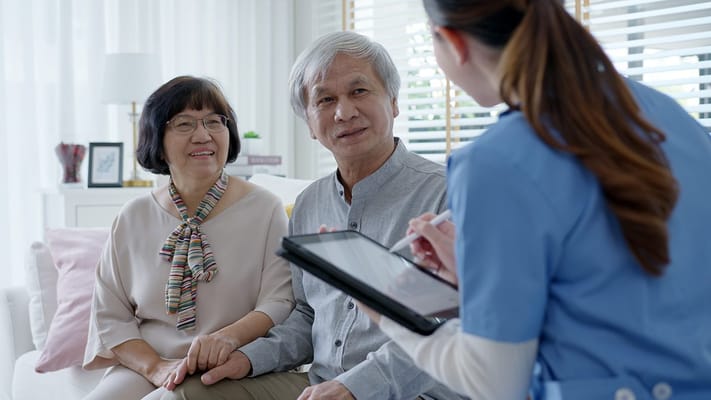 A caregiver talking with senior residents indoors