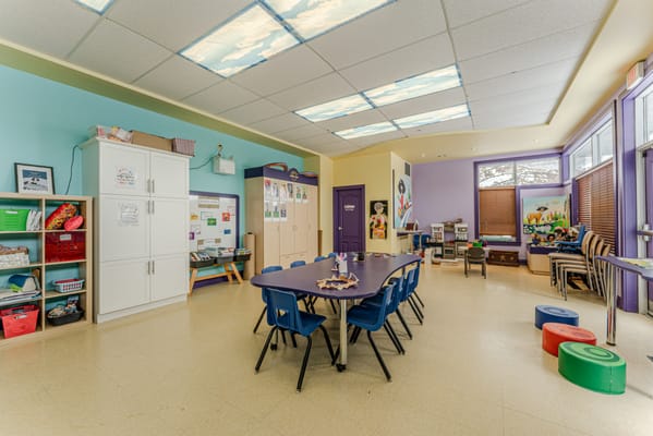 Bright and colorful activity room with tables and chairs