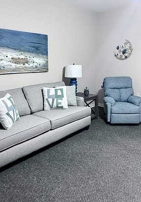 Cozy lounge area with a sofa and recliner chair