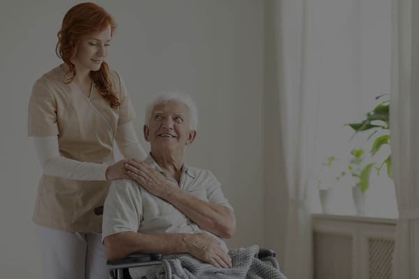 A caregiver assisting a resident in a bright room