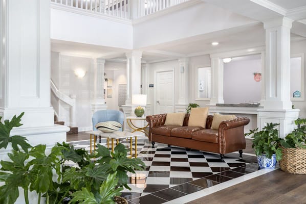 Common area with a couch and plants in a bright lobby