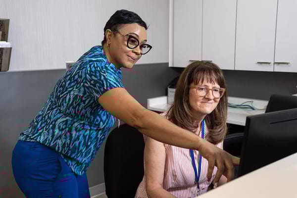 Staff assisting residents at a computer workstation