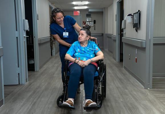 Care staff assisting a resident in a hallway