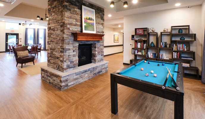 Interior common area with pool table and bookshelves