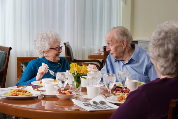 Residents enjoying a meal together in the dining room