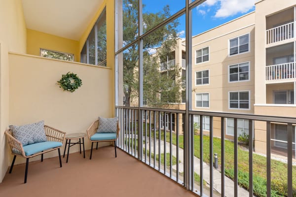 View of a cozy balcony with seating overlooking the courtyard