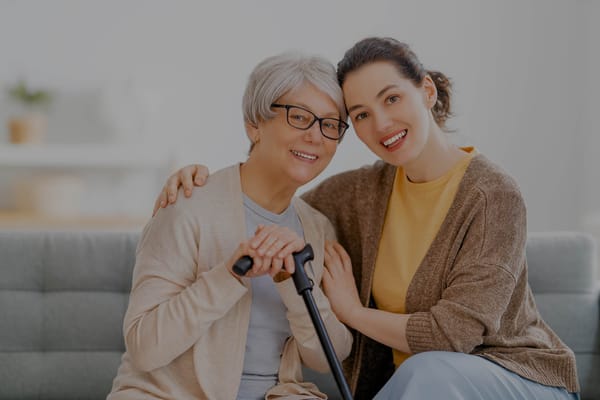 A caregiver embracing a smiling resident in a cozy room