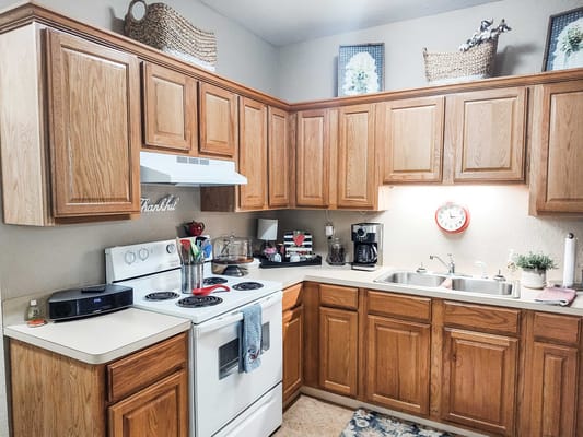Bright kitchen area with wooden cabinets and appliances