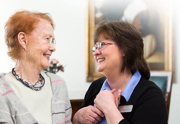 A resident and staff member sharing a joyful moment