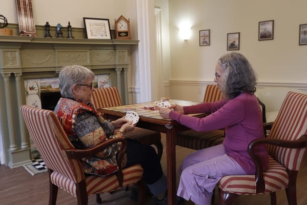 Two residents playing cards in a common area