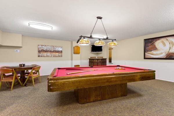 Interior game room with a pool table and seating
