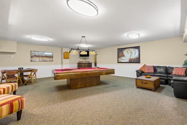 Interior game room with a pool table and seating