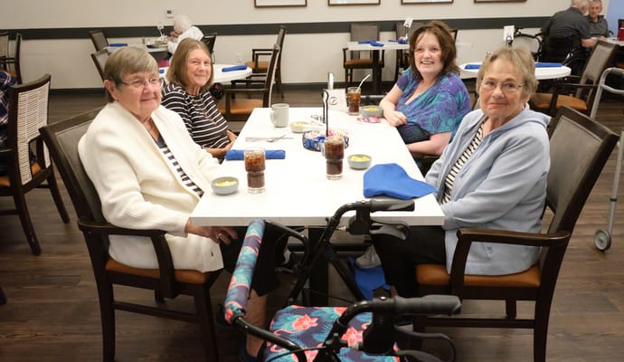 Four residents enjoying refreshments in the dining area