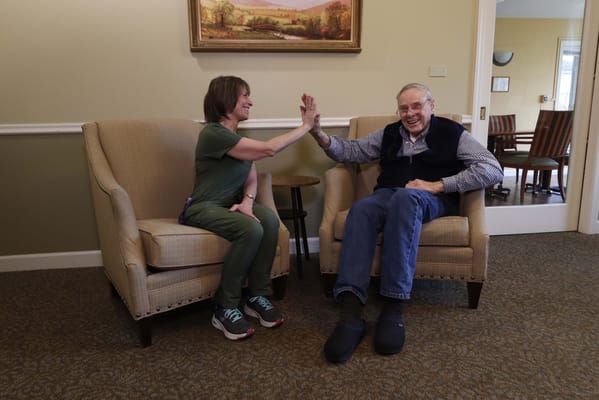 A caregiver and resident sharing a moment in the facility.