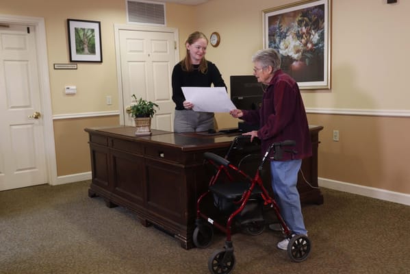 Staff assisting resident at the reception desk