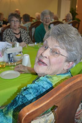 A resident smiling during a group meal