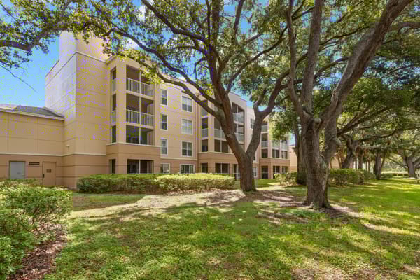 Exterior view of a senior living facility surrounded by trees