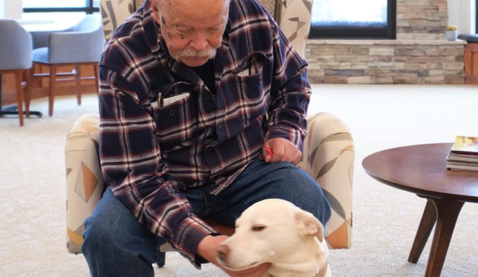 Resident interacting with a dog in a common area