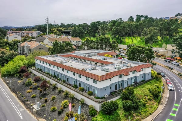 Aerial view of the facility building with gardens and surrounding landscape
