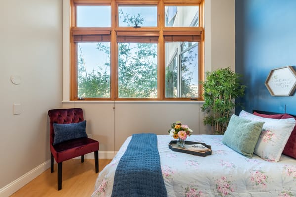 A well-decorated bedroom with floral bedding and a plant