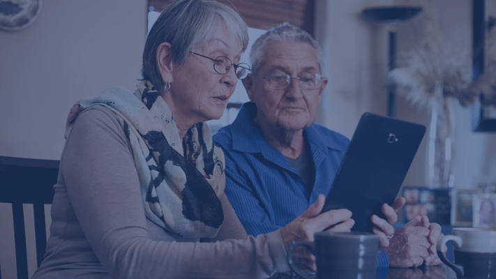 Two residents engaging with a tablet indoors