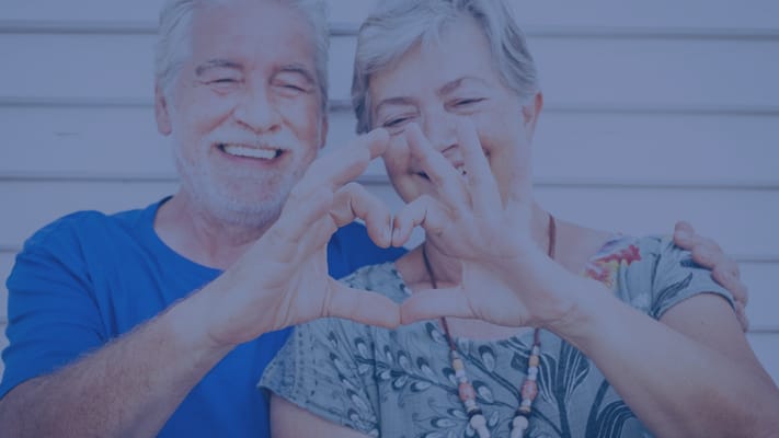 A senior couple making a heart shape with their hands