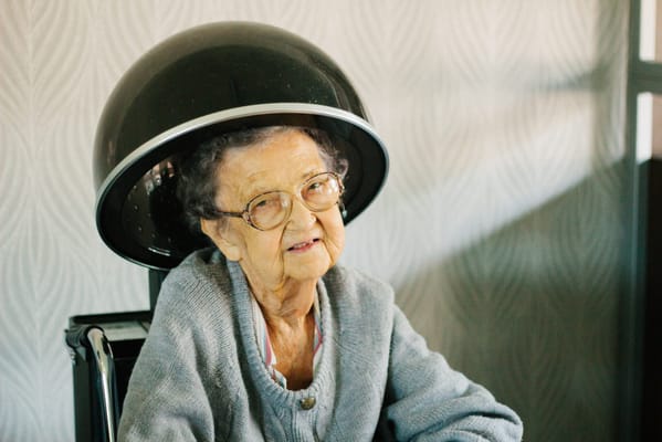 Resident enjoying a salon treatment in a cozy setting