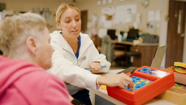Staff member engaging with a resident during an activity