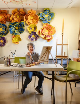 A resident painting in an arts activity room