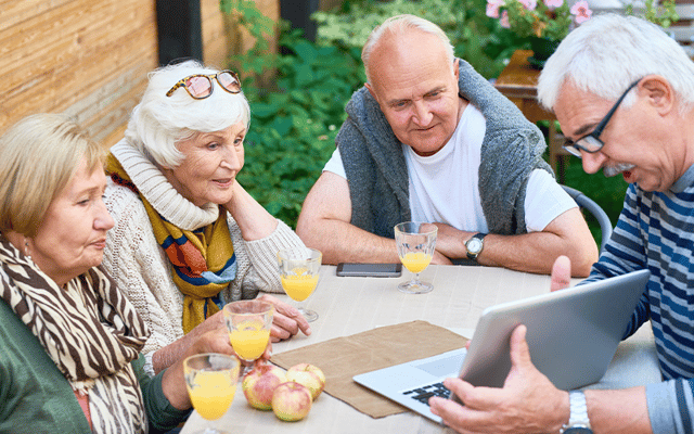 Residents enjoying drinks and laptop activities outdoors