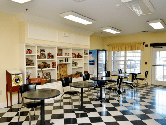 Common area with tables and chairs in nursing home