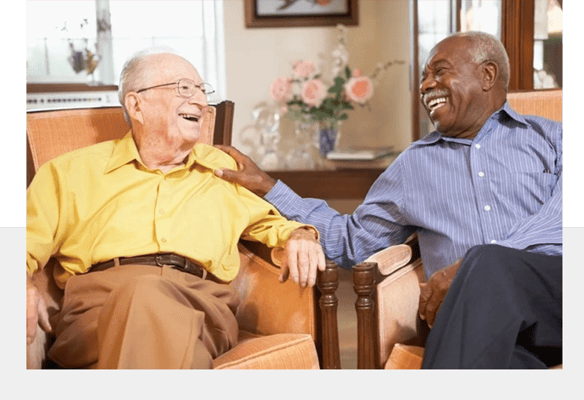 Two elderly men enjoying a conversation in a common area