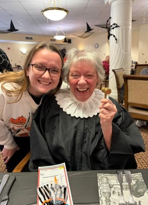 Resident and staff member celebrating an event with smiles