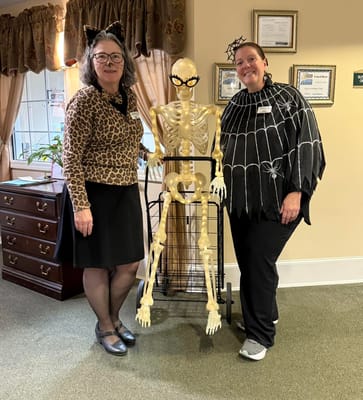 Staff in costumes with a skeleton decoration in a common area