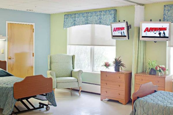 Interior view of a resident room with furniture and TV