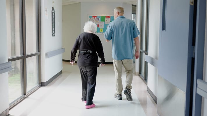 Staff assisting a resident in a hallway