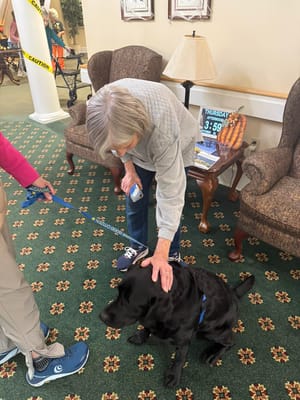 Resident interacting with a therapy dog in the lobby
