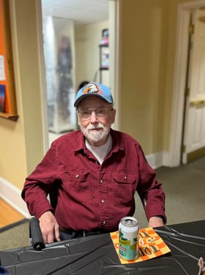 Resident sitting at a table in the facility's common area