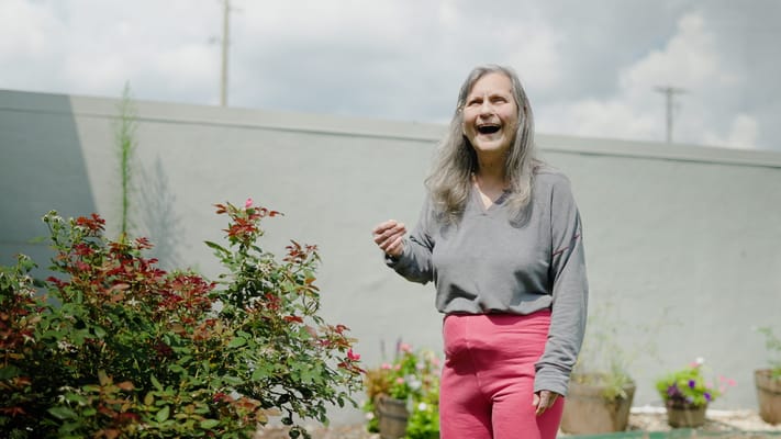 A resident enjoying the garden with vibrant flowers.