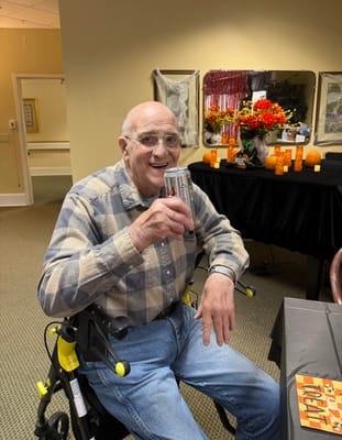 Resident enjoying a drink in a decorated common area