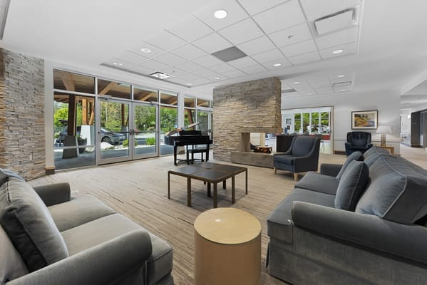Bright common area with seating and a piano