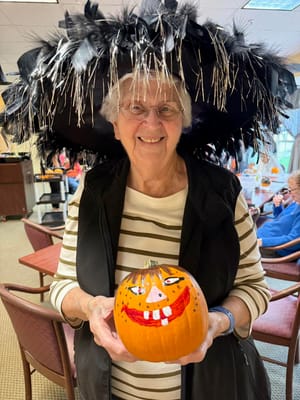 Resident with a decorated pumpkin during a festive celebration