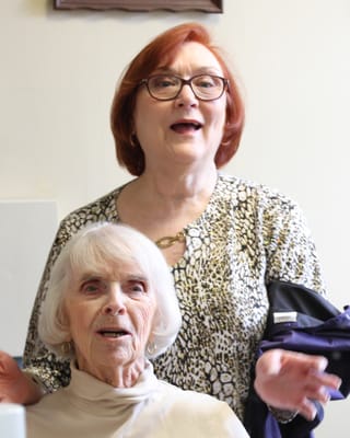 Two women smiling in a bright room