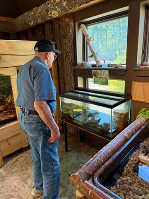 A resident observing a fish tank in a common area