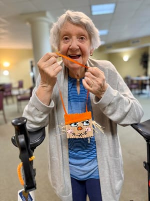 Resident smiling and holding a craft project