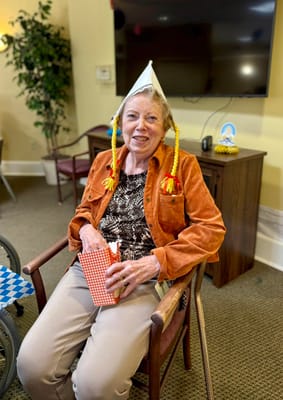 Resident celebrating with party hat and snacks