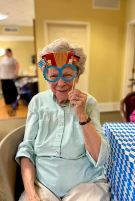 A resident enjoying a festive activity with playful glasses