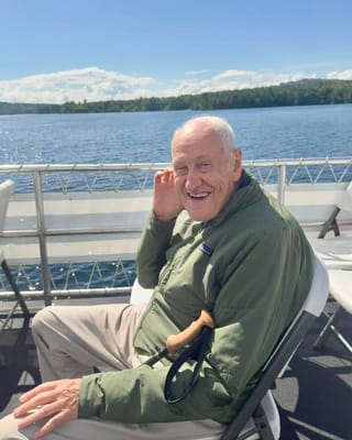 Elderly man smiling on a boat by the water
