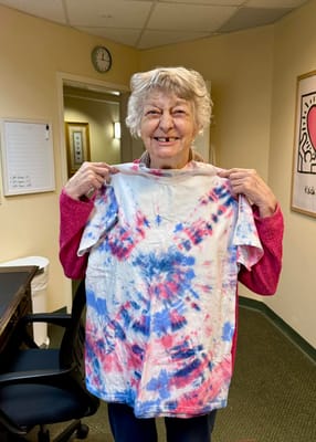 Resident proudly displaying a tie-dye shirt in a facility common area